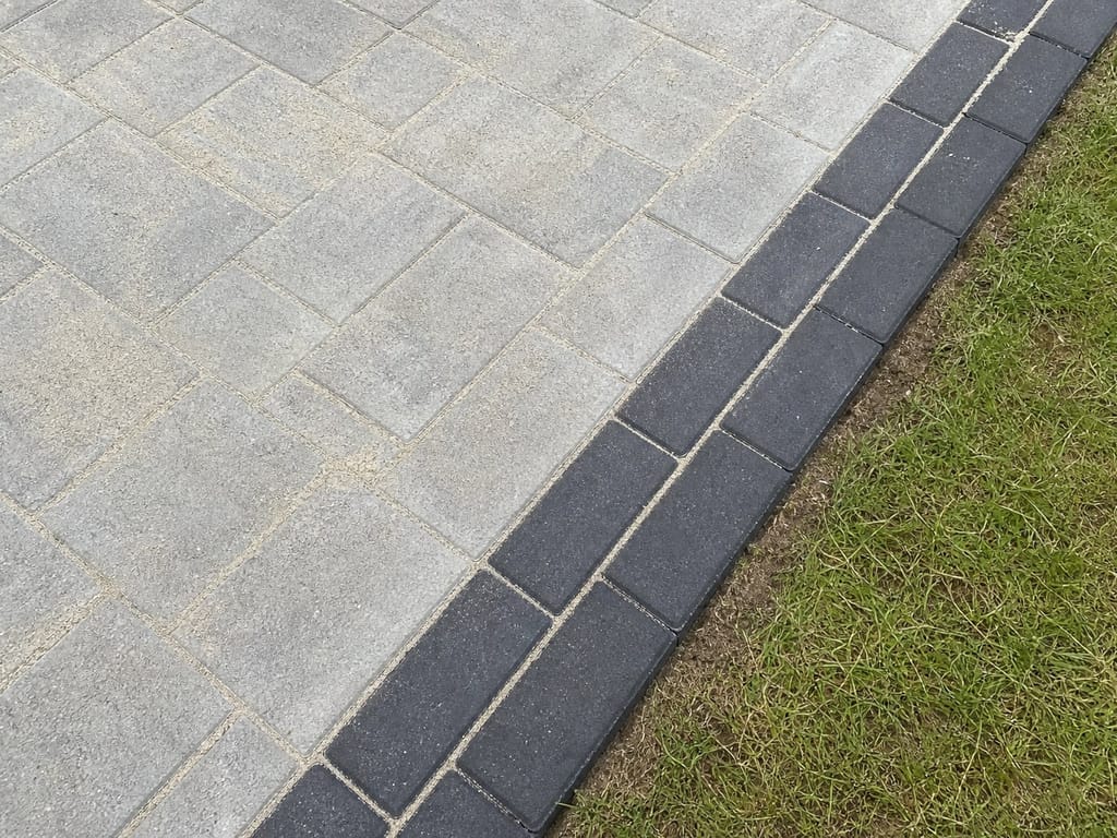Double charcoal soldier border along the edge of silver grey block paving