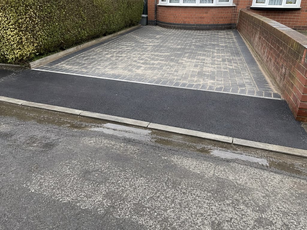Dropped kerb and fresh tarmac apron where the drive meets the road